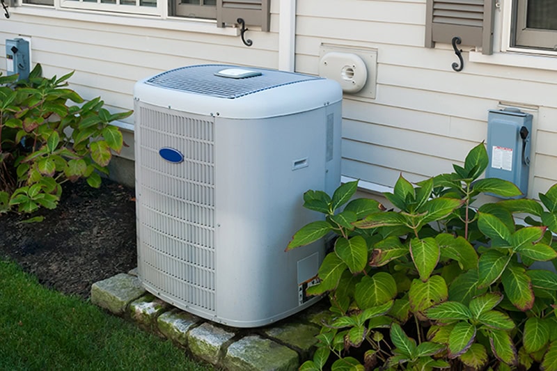 Spring AC Maintenance Tips. Photo of an HVAC installed outside of a home.